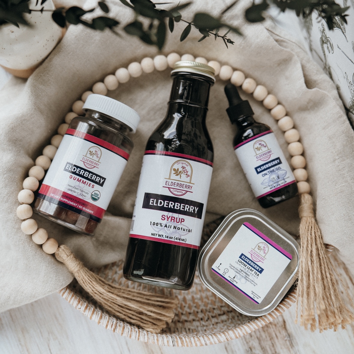Collection of wellness essentials including elderberry syrup, gummies, and tincture for daily health support.